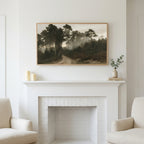 Misty pine forest path art above a white fireplace with candles and eucalyptus on the mantel