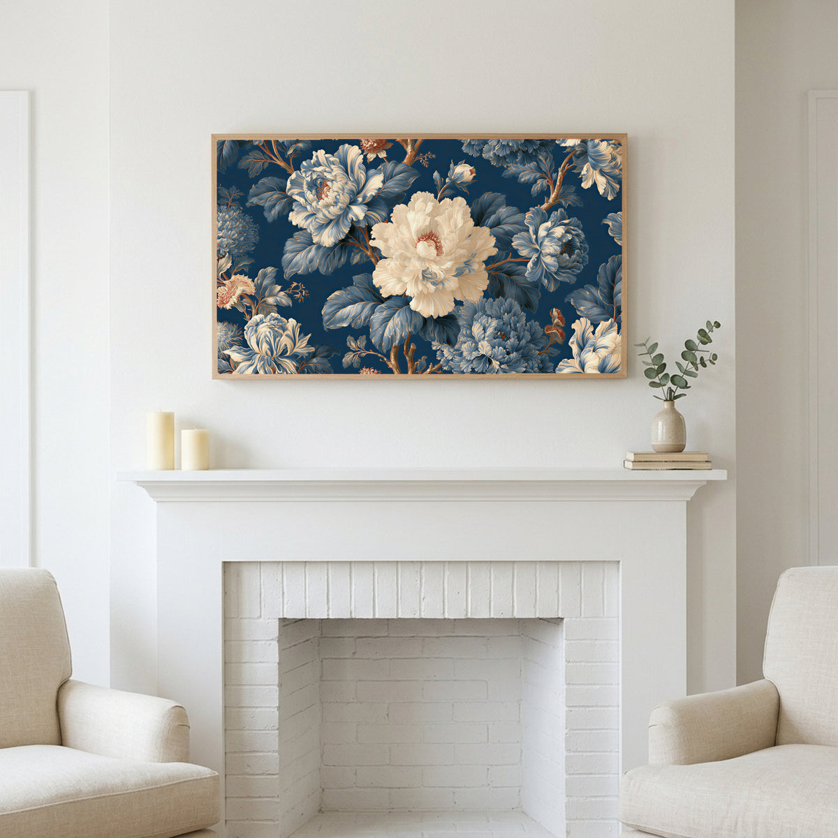Blue and cream peonies art above a white fireplace with candles and eucalyptus on the mantel
