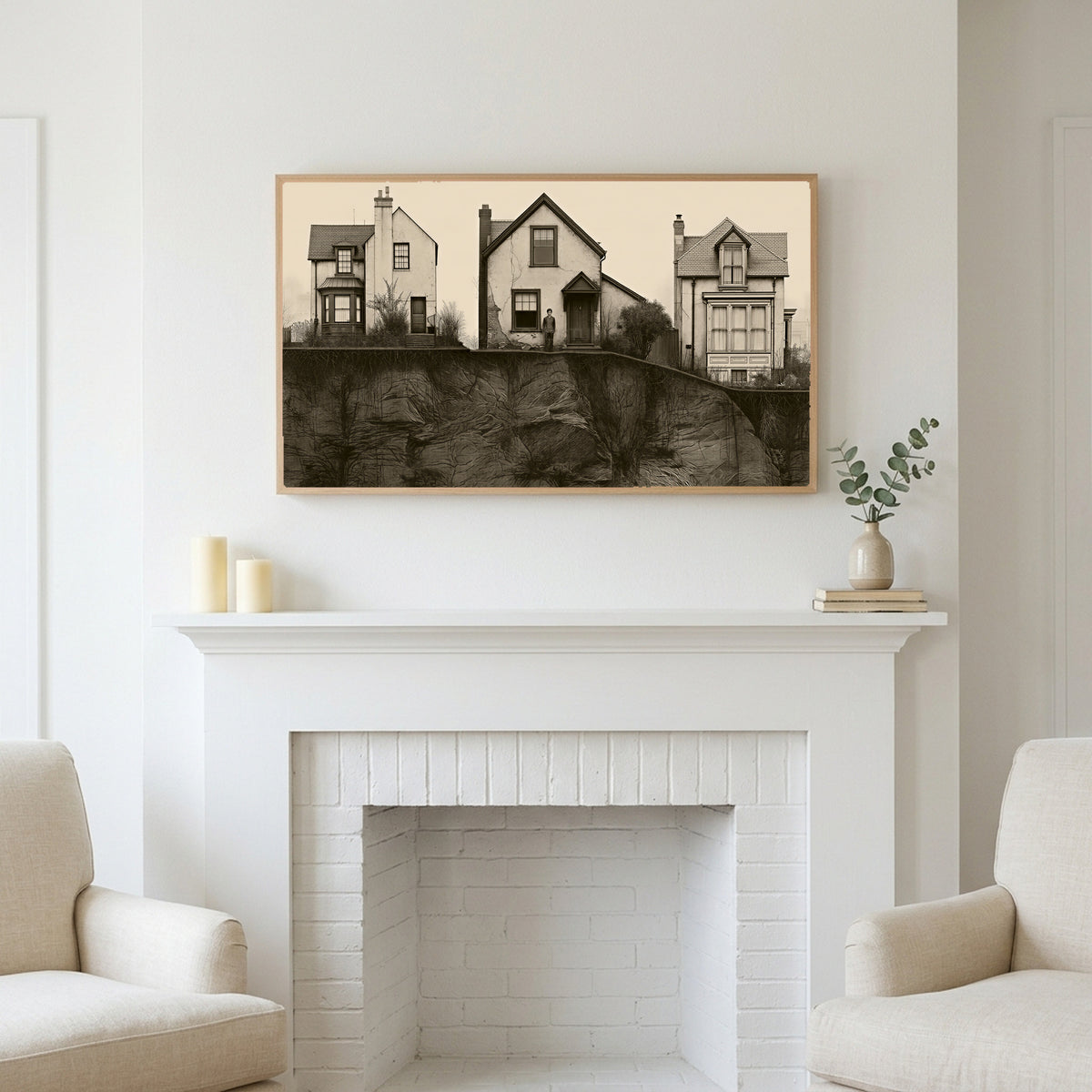 Three houses art above a white fireplace with candles and eucalyptus on the mantel