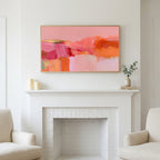Pink abstract color blocks art above a white fireplace with candles and eucalyptus on the mantel