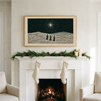 Three wise men art on a TV above a white fireplace with a pine garland and cream stockings