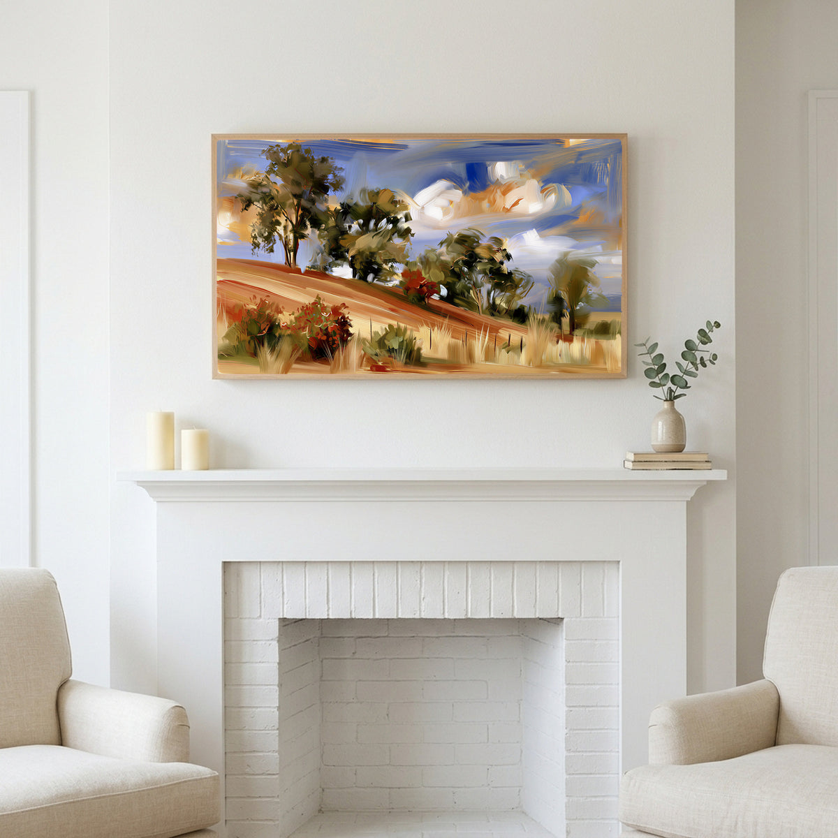 Hillside trees art above a white fireplace with candles and eucalyptus on the mantel