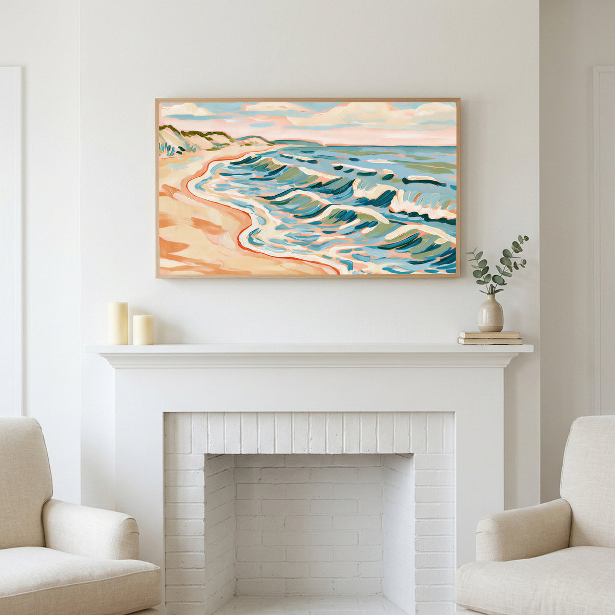 Beach waves art above a white fireplace with candles and eucalyptus on the mantel