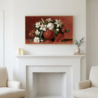 White lilies in a red vase art above a white fireplace with candles and eucalyptus on the mantel