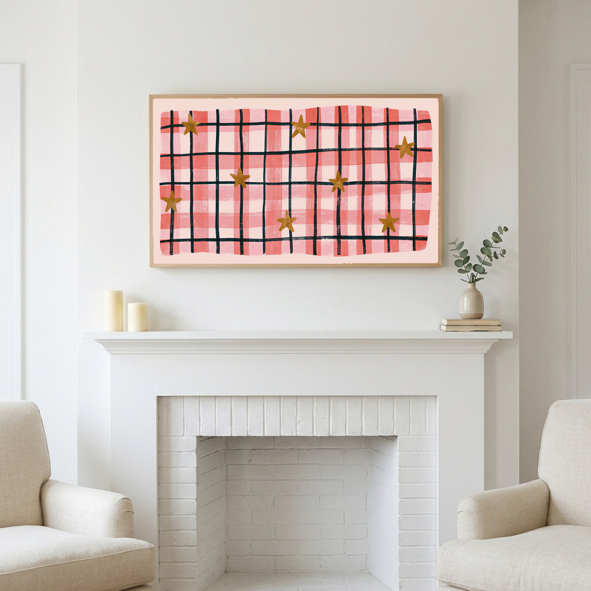 Gingham plaid with stars art above a white fireplace with candles and eucalyptus on the mantel