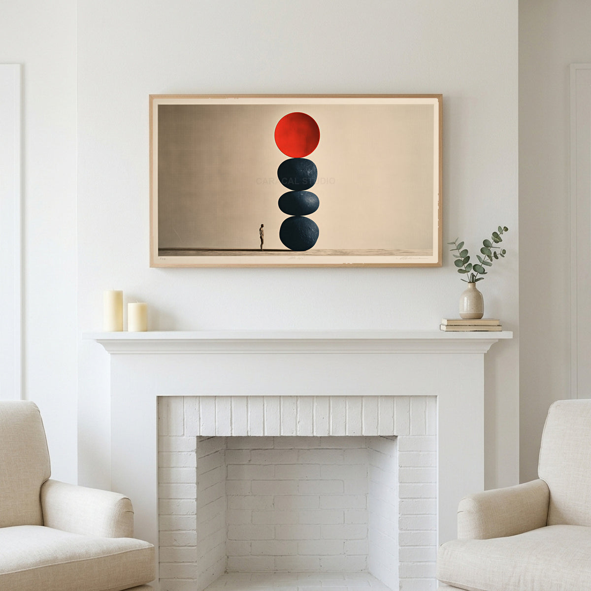 Stacked stones art above a white fireplace with candles and eucalyptus on the mantel