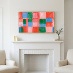 Painted checks art above a white fireplace with candles and eucalyptus on the mantel