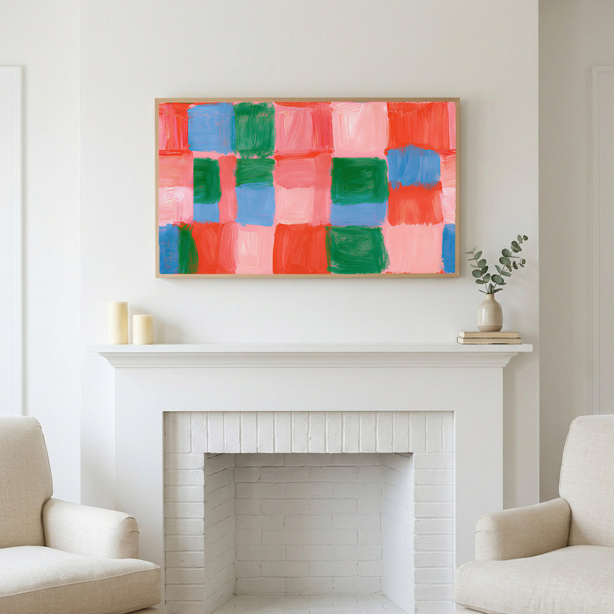 Painted checks art above a white fireplace with candles and eucalyptus on the mantel