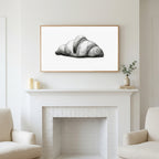 Croissant etching art above a white fireplace with candles and eucalyptus on the mantel