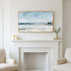 Snowy landscape art above a white fireplace with candles and eucalyptus on the mantel