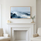 Ocean waves art above a white fireplace with candles and eucalyptus on the mantel