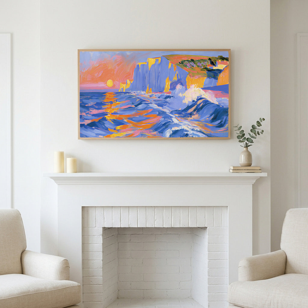 Sunset sea cliffs art above a white fireplace with candles and eucalyptus on the mantel