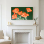 Blurred orange poppies art above a white fireplace with candles and eucalyptus on the mantel