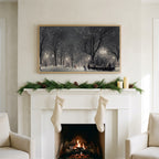 New York park at night art on a TV above a white fireplace with a pine garland and cream stockings
