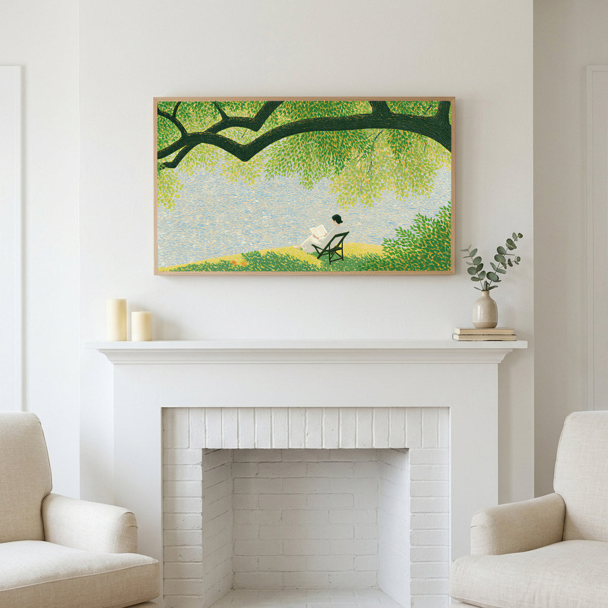 Lake and tree landscape art above a white fireplace with candles and eucalyptus on the mantel