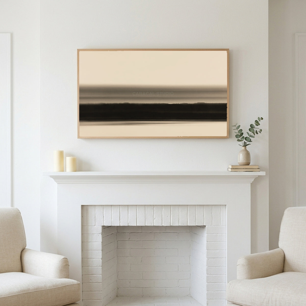 Ink wash horizon art above a white fireplace with candles and eucalyptus on the mantel