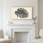 Monstera leaf art above a white fireplace with candles and eucalyptus on the mantel