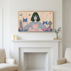 Astrology and cats art above a white fireplace with candles and eucalyptus on the mantel