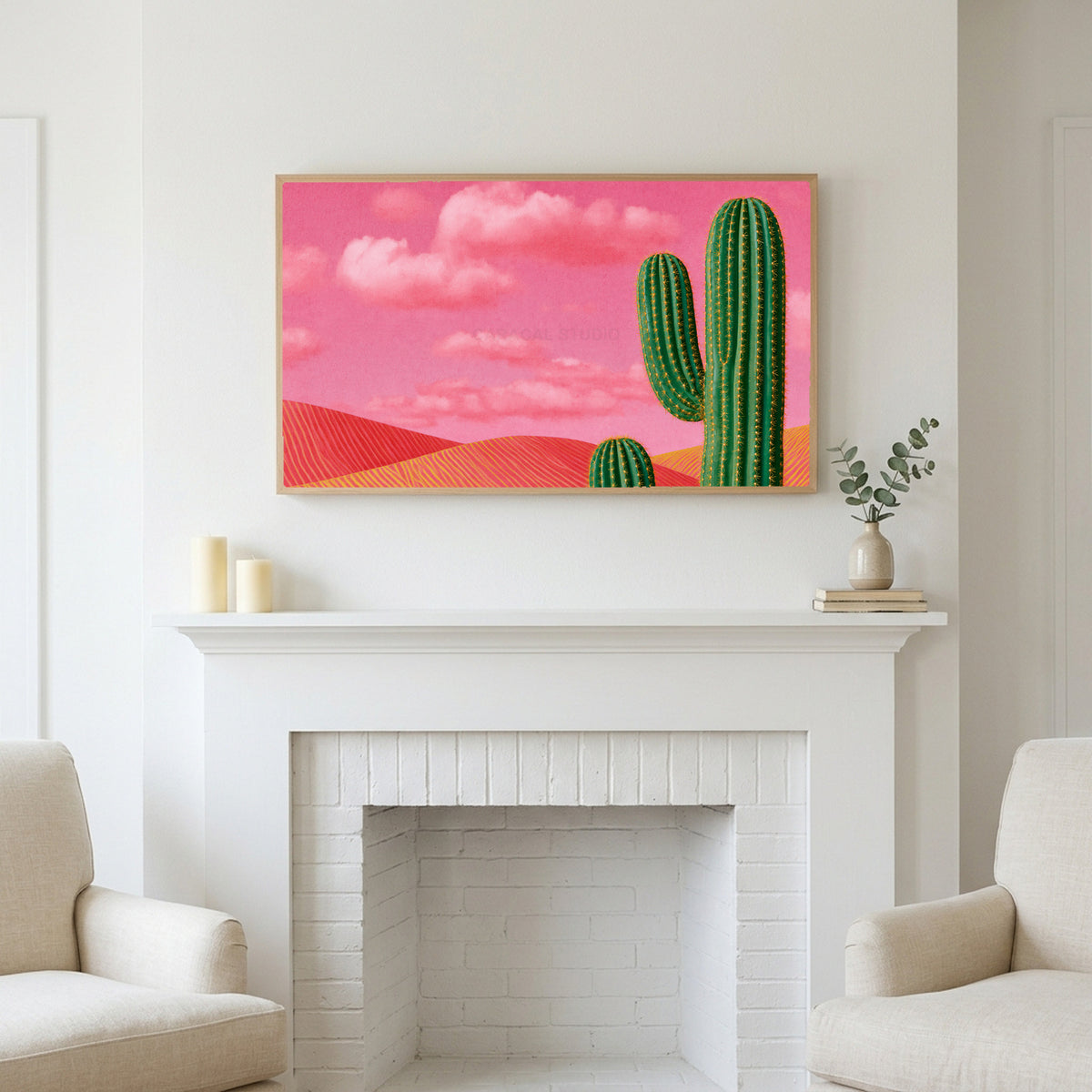 Saguaro cactus art above a white fireplace with candles and eucalyptus on the mantel