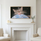 Space cat art above a white fireplace with candles and eucalyptus on the mantel