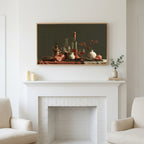 Wine and pomegranates still life art above a white fireplace with candles and eucalyptus on the mantel