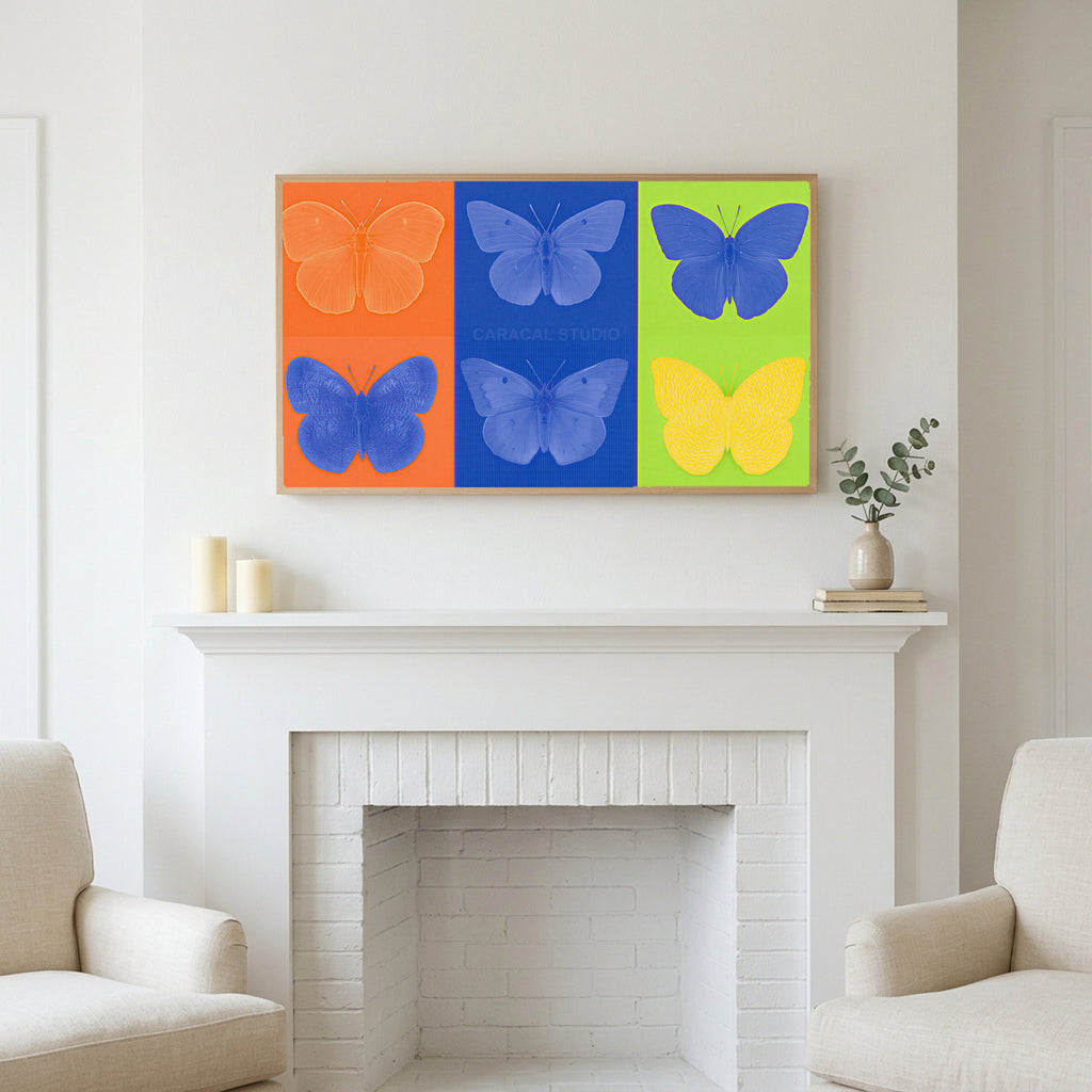 Pop art butterfly art above a white fireplace with candles and eucalyptus on the mantel