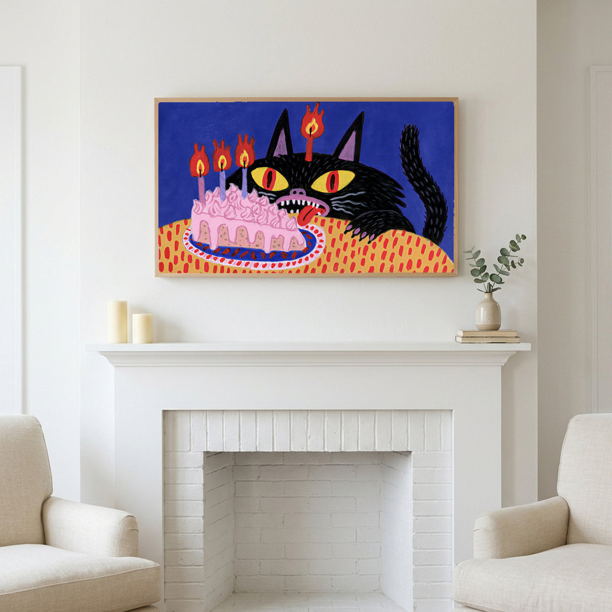 Birthday cat art above a white fireplace with candles and eucalyptus on the mantel