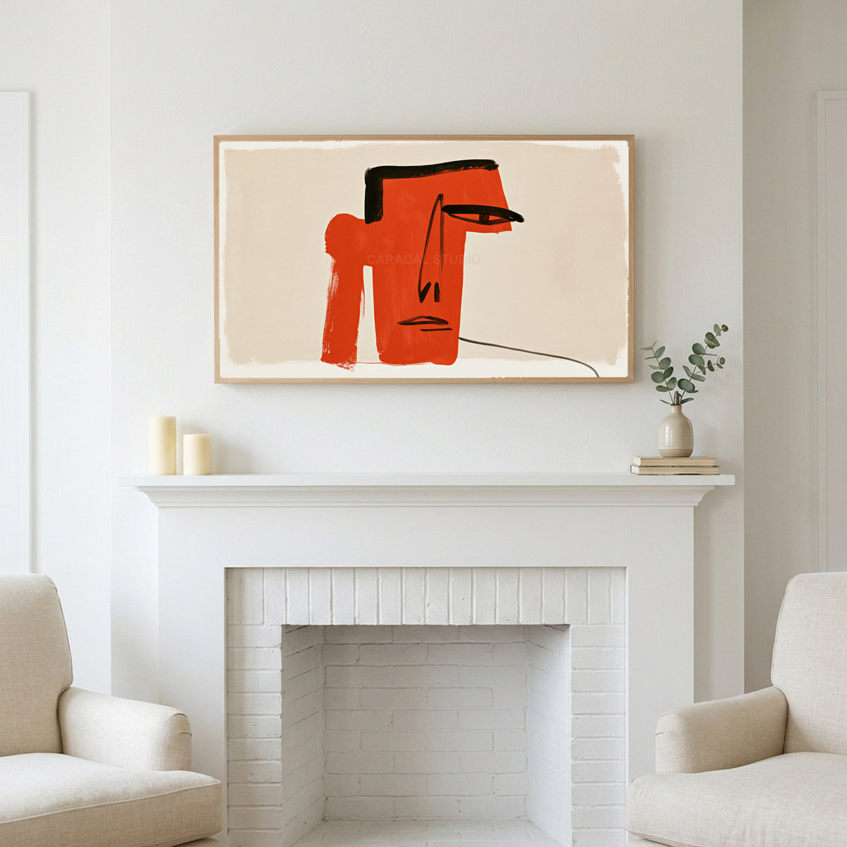 Red block face art above a white fireplace with candles and eucalyptus on the mantel