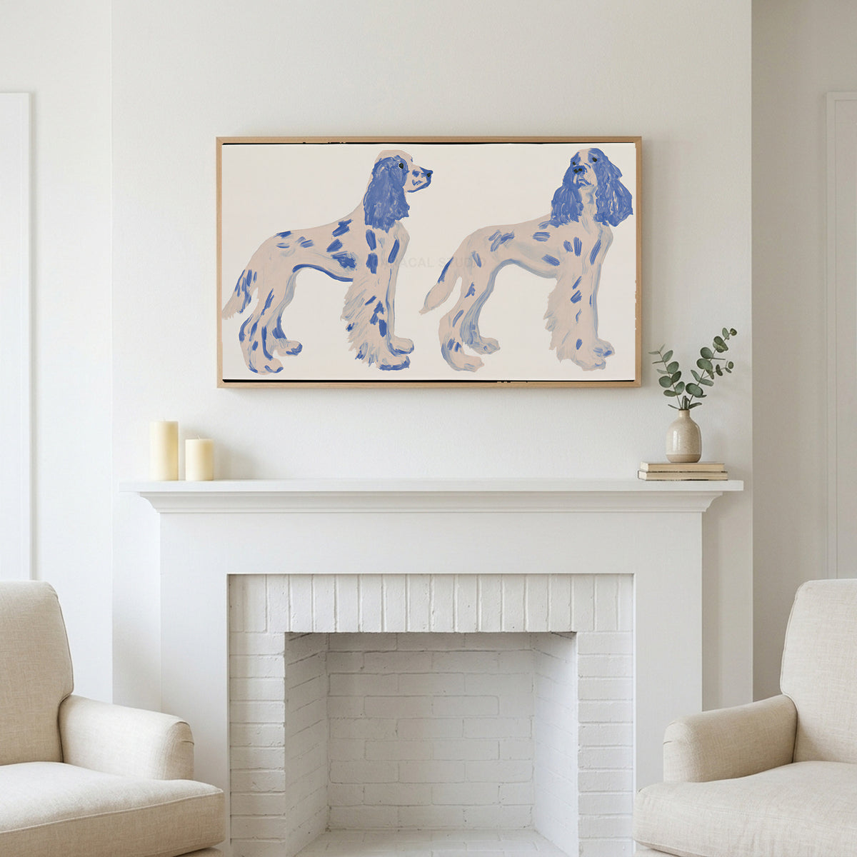 Frame TV art above a white fireplace with candles and eucalyptus on the mantel