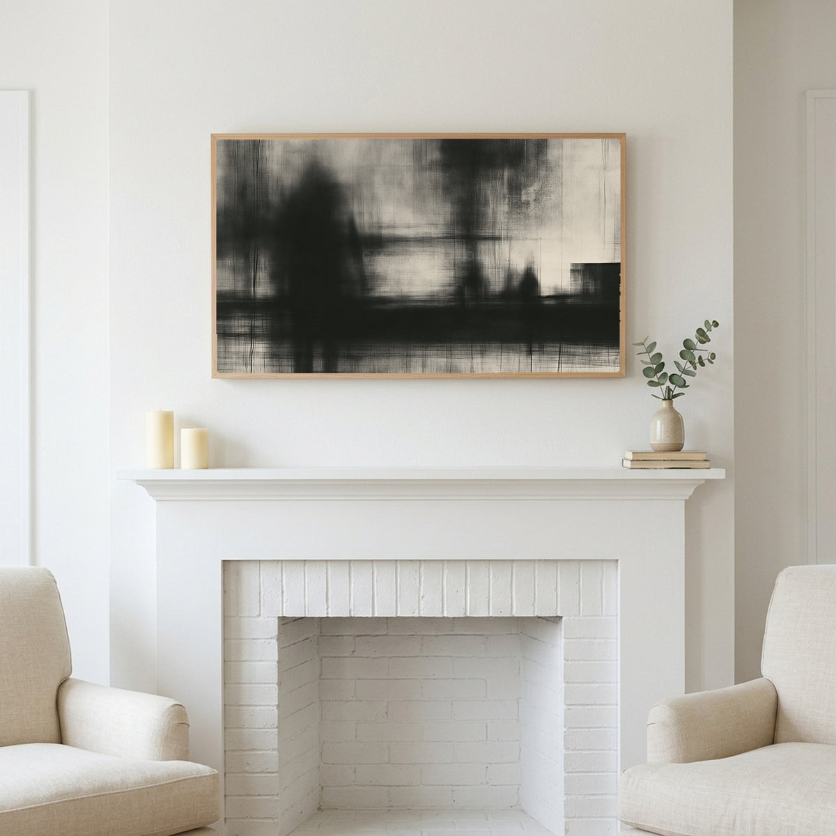 Black and white abstract art above a white fireplace with candles and eucalyptus on the mantel