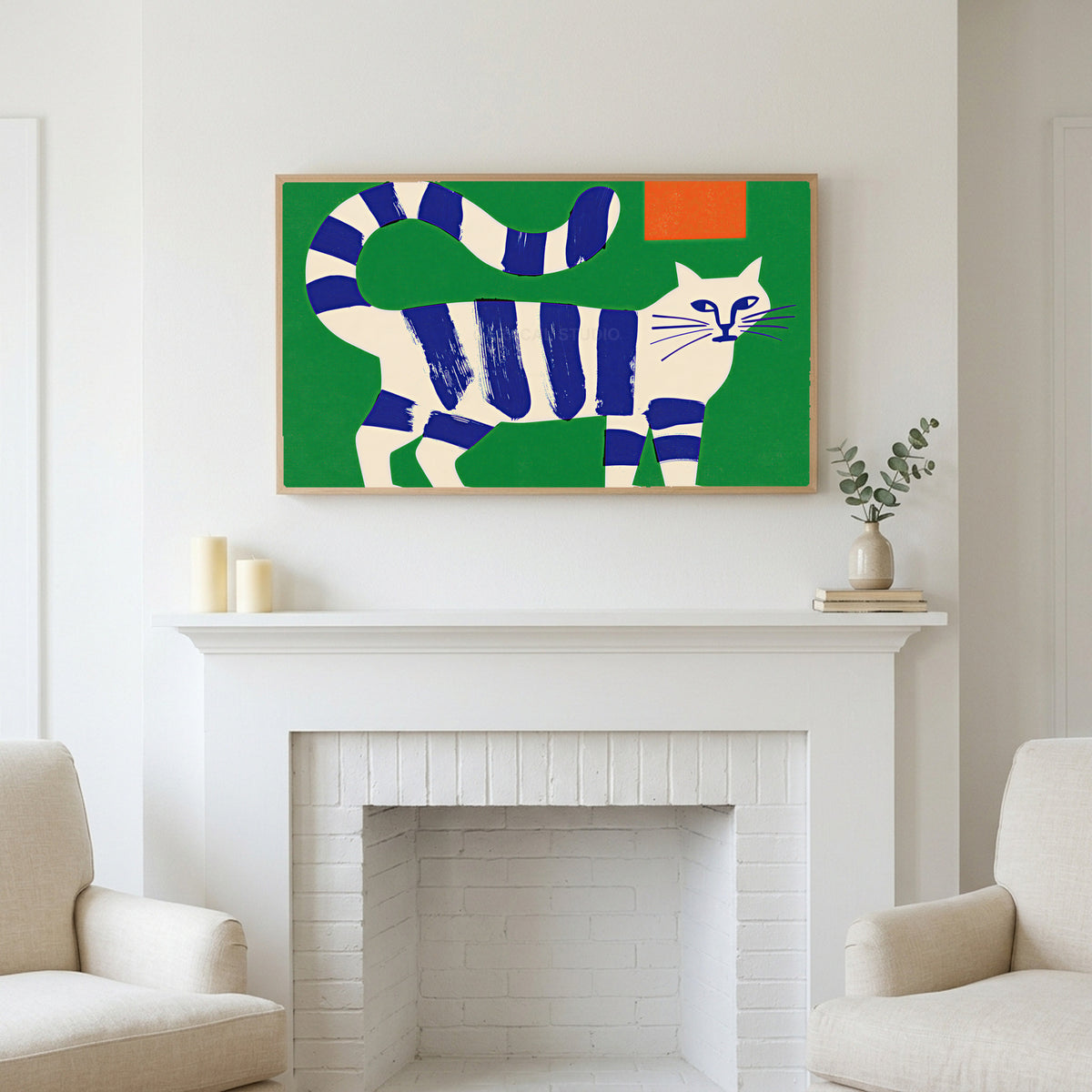 Blue striped cat art above a white fireplace with candles and eucalyptus on the mantel
