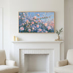 Pink spring flower buds art above a white fireplace with candles and eucalyptus on the mantel