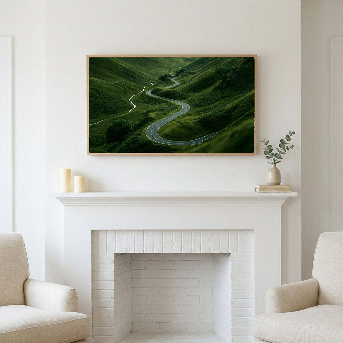 Winding road landscape art above a white fireplace with candles and eucalyptus on the mantel