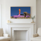 Pink car in the desert art above a white fireplace with candles and eucalyptus on the mantel