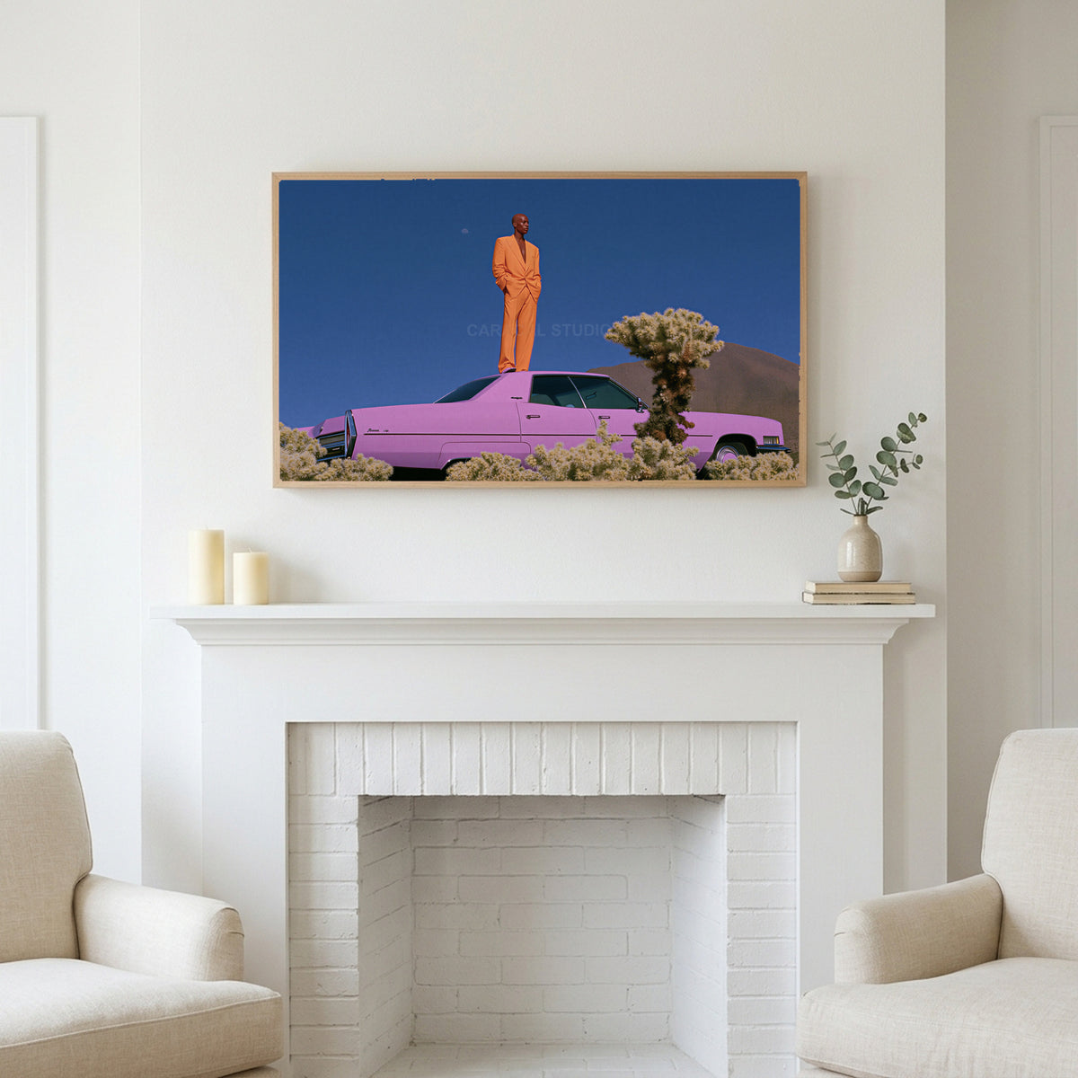 Pink car in the desert art above a white fireplace with candles and eucalyptus on the mantel