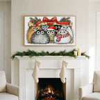 Cats under a gift box art on a TV above a white fireplace with a pine garland and cream stockings