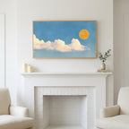 Sun and clouds art above a white fireplace with candles and eucalyptus on the mantel