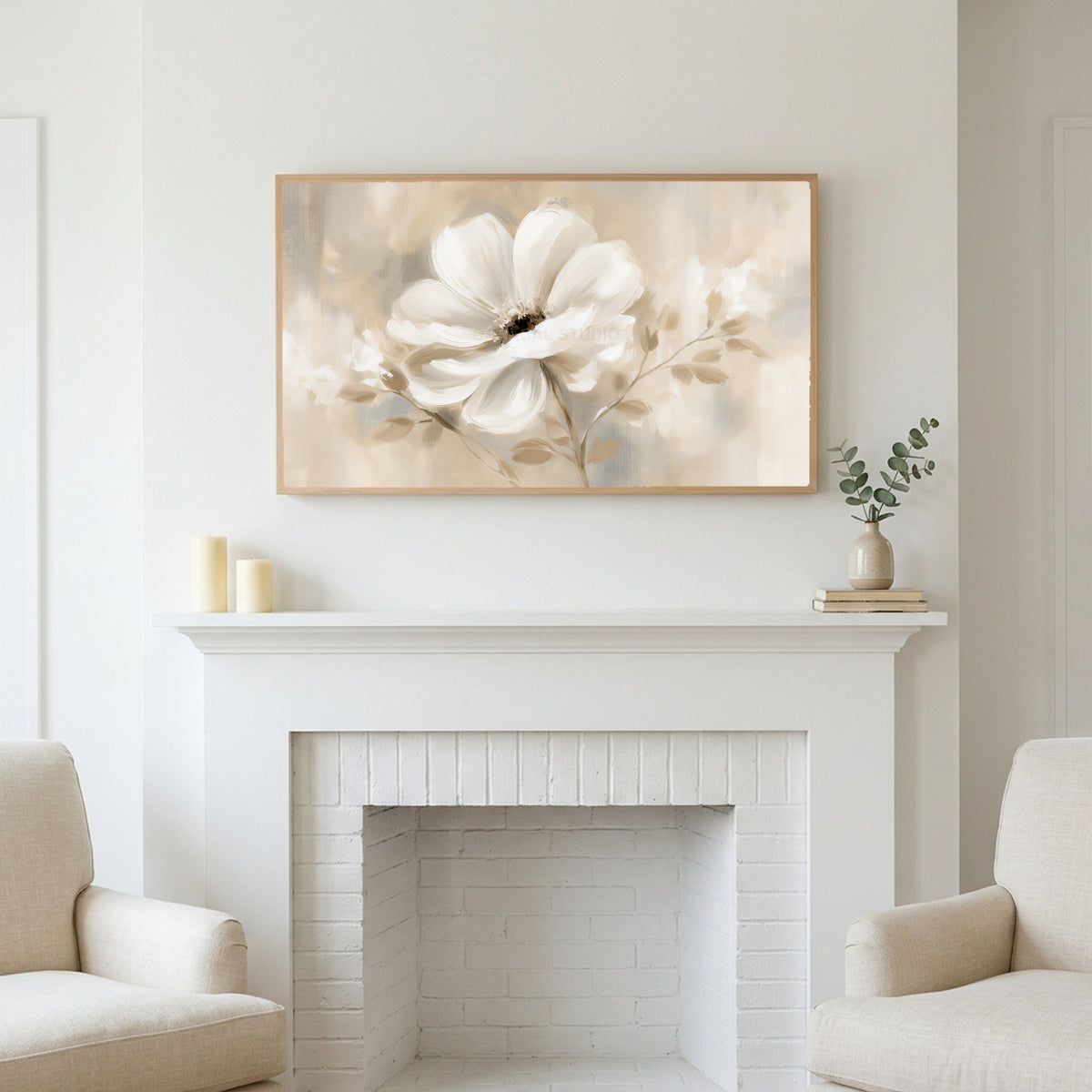 White flower art above a white fireplace with candles and eucalyptus on the mantel