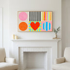 Colorful shapes and heart art above a white fireplace with candles and eucalyptus on the mantel