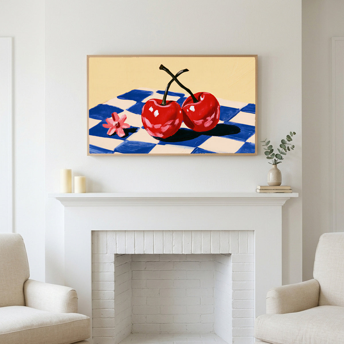Cherry still life art above a white fireplace with candles and eucalyptus on the mantel