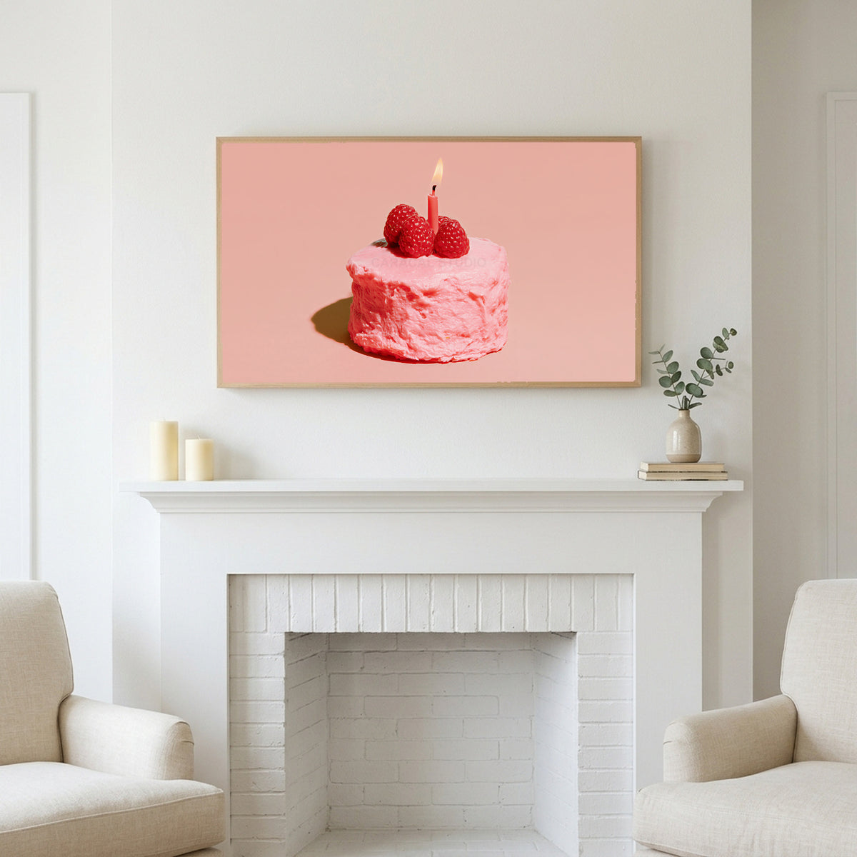 Birthday cake art above a white fireplace with candles and eucalyptus on the mantel