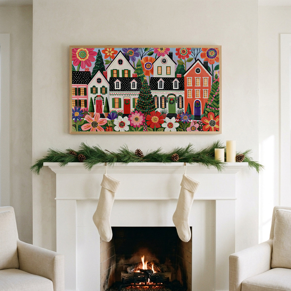 Folk art Christmas village art on a TV above a white fireplace with a pine garland and cream stockings
