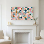 Pastel pebble mosaic art above a white fireplace with candles and eucalyptus on the mantel