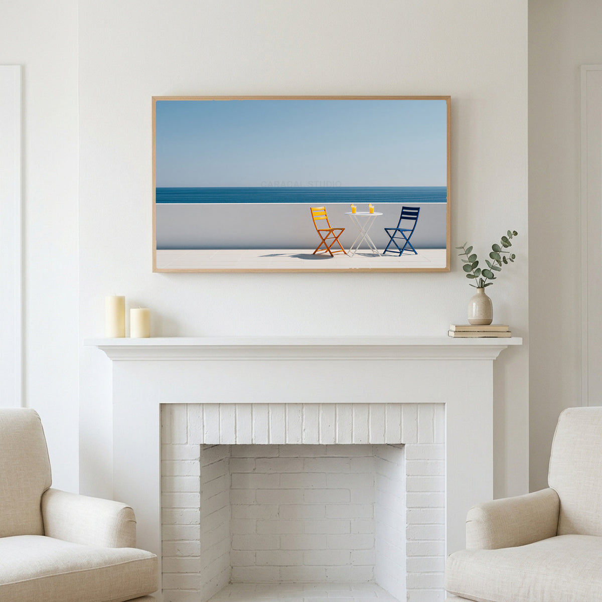 Ocean view terrace art above a white fireplace with candles and eucalyptus on the mantel
