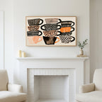 Stacked teacups art above a white fireplace with candles and eucalyptus on the mantel