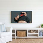 Cool duck Frame TV art above a white console with a rattan basket in a coastal living room