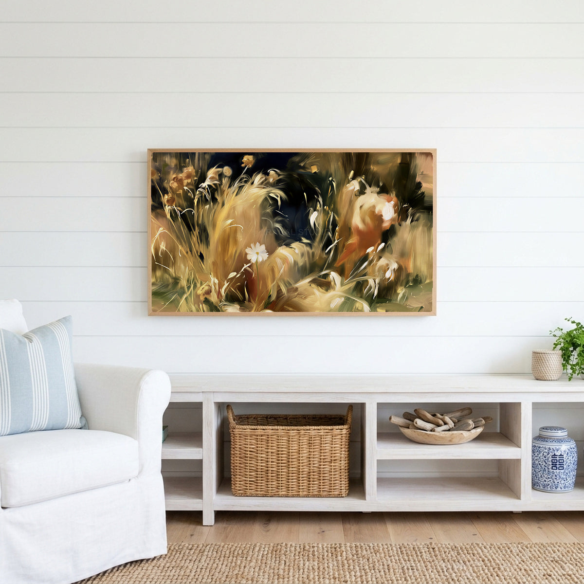 Wild grass and white flower Frame TV art above a white console with a rattan basket in a coastal living room