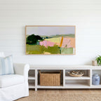 Abstract countryside Frame TV art above a white console with a rattan basket in a coastal living room