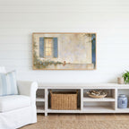 Blue shutter cottage window Frame TV art above a white console with a rattan basket in a coastal living room