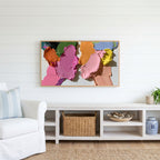 Pastel paint strokes Frame TV art above a white console with a rattan basket in a coastal living room